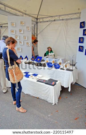 FAENZA, ITALY- SEPTEMBER 7, 2014: items on display and vendor at the ceramic Sunday open market. The market is very popular in the city and attracts thousands of people.