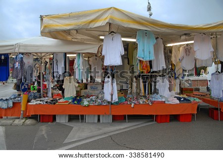CERVIA, ITALY-MAY 16, 2015: clothing vendor at the Saturday outdoor market. The place is very popular in the city and attracts thousands of people.