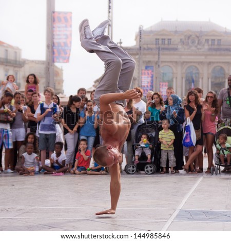 MONTPELLIER - JULY 12: Street performer breakdancing in front of the random crowd on July 12, 2011 in  Montpellier, France; B-boying is a style of street dance that originated in NY in early 1970s.