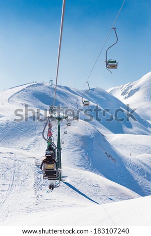 Skiers on ski lift the ski slopes in  Alp mountains, Triglav natural park, Vogel, Bohinj, Slovenia.