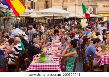 ROME, ITALY - JUNE 13 2014: People having aperitif which in Italy traditionally includes free all you can eat buffet of pizzas and pastas, on JUNE 13 2014 on Piazza Campo De Fiori in Rome in Italy.