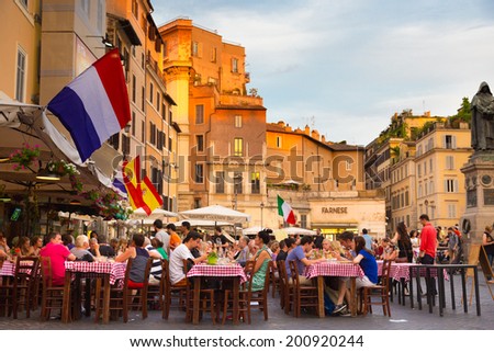 ROME, ITALY - JUNE 13 2014: People having aperitif which in Italy traditionally includes free all you can eat buffet of pizzas and pastas, on JUNE 13 2014 on Piazza Campo De Fiori in Rome in Italy.