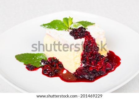 Cremeschnitte with Berries Sauce and Green Mint. It is a vanilla and custard cream cake dessert popular in several central-European countries. It includes puff pastry base and custard cream.