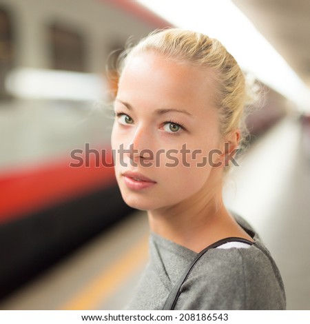 Young woman  waiting on the platform of a railway station for their train. to arrive.