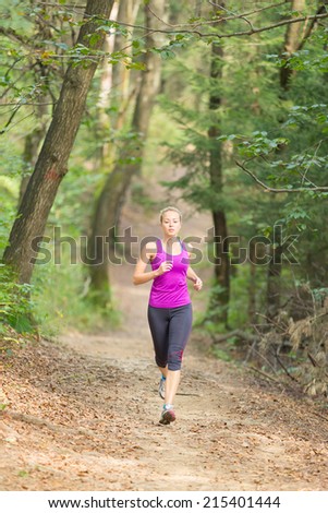 Pretty young girl runner in the forest.  Running woman. Female Runner Jogging during Outdoor Workout in a Nature. Beautiful fit Girl. Fitness model outdoors. Weight Loss. Healthy lifestyle.
