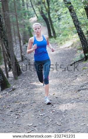 Pretty young girl runner in the forest.  Running woman. Female Runner Jogging during Outdoor Workout in a Nature. Beautiful fit Girl. Fitness model outdoors. Weight Loss. Healthy lifestyle.