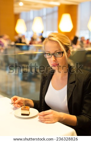 Business woman eating her favorite dessert in a fancy modern hotel restaurant. Unable to resist our sweet vices. Lifestyles.