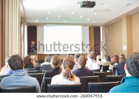 Speaker at Business Conference and Presentation. Audience in the conference hall. Business and Entrepreneurship. Copy space on white screen.