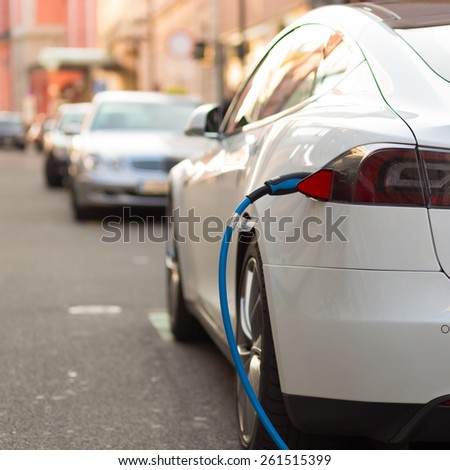 Power supply for electric car charging Electric car charging station Close up of the power supply plugged into an electric car being charged Power supply for electric car charging Electric car charging station Close up of the power supply plugged into an electric car being charged