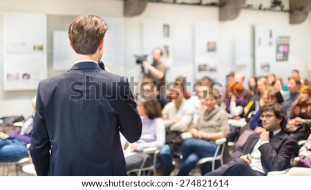 Speaker Giving a Talk at Business Meeting. Audience in the conference hall. Business and Entrepreneurship. Copy space on white board.