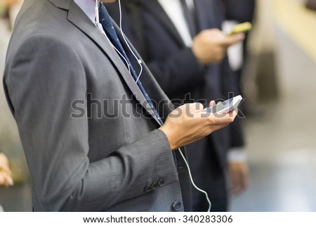 Businessmen using their cell phones on Tokyo subway. Horizontal composition. Business travel and communication concept.