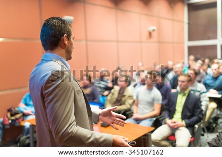 Speaker at Business Conference with Public Presentations. Audience at the conference hall. Business and Entrepreneurship concept. Background blur. Shallow depth of field.