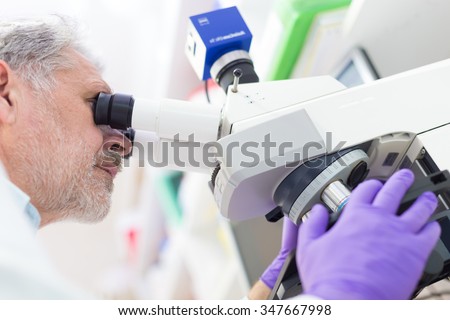 Senior head scientist  microscoping in the life science research laboratory ( diagnostics, biochemistry, pharmacy, genetics, forensics, microbiology, pharmacogenetics ...)