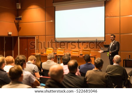 Speaker giving a talk in conference hall at business event. Audience at the conference hall. Business and Entrepreneurship concept. Copy space on white screen.