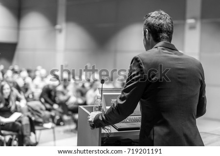 Speaker giving a talk on corporate Business Conference. Audience at the conference hall. Business and Entrepreneurship event. Black and white image.