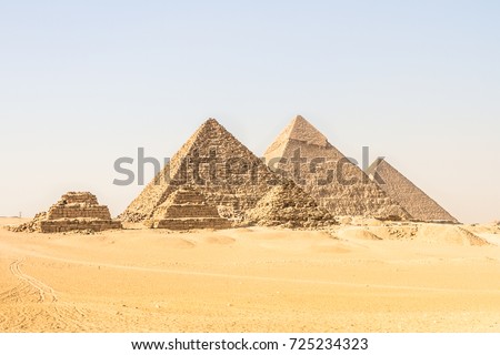 Giza pyramids in Cairo, Egypt. General view of pyramids from the Giza Plateau Three pyramids known as Queens\' Pyramids on front side. Next in order from left, the Pyramid of Menkaure, Khafre and Chufu