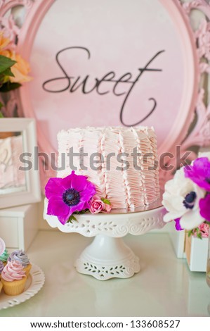 Dessert table for a party. Ombre cake and flowers
