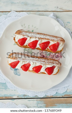 Eclair with whipped cream and strawberries