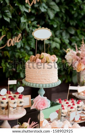 Dessert table for a party. Ombre cake, sweets and flowers