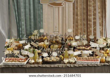Dessert table for a party. gugelhupf with bilberries, fig and cream, cupcakes, sweetness and flowers