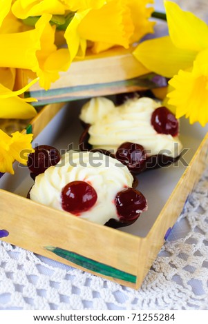 white protein mousse dessert served with cherry in an edible chocolate cup in a gift box