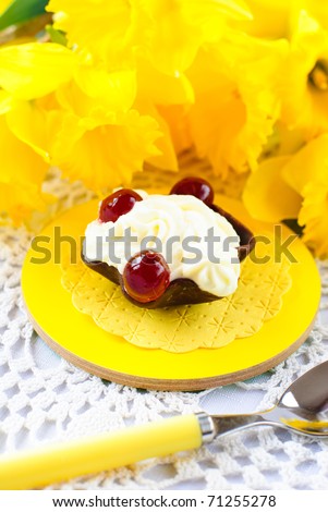 white protein mousse dessert served with cherry in an edible chocolate cup and daffodil flowers
