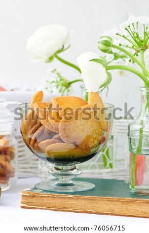 heart shaped cookies into a glass and a fresh bouquets of white ranunculus