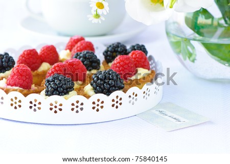 delicious fresh berry cakes, cup of tean and a flowers
