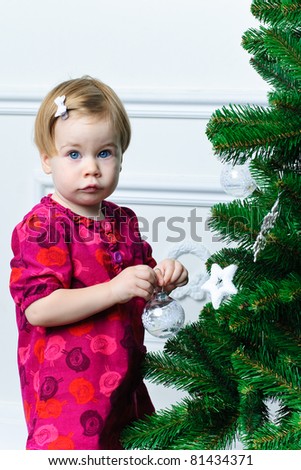 Little girl decorating Christmas tree on white background