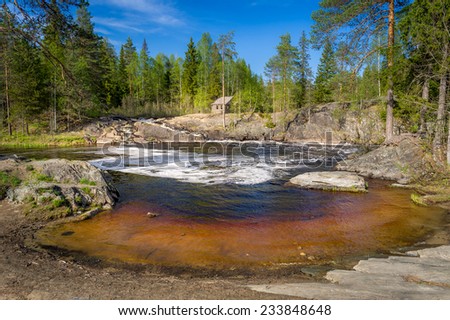 Small beautiful forest pond and wooden house in Karelia. Russian nature.