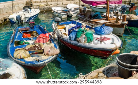 Old-fashioned mediterranean fishing boats with colorful bags and nets moored. Petrovac marina, Montenegro