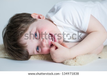 Cute young boy lying on floor watches television/computer for fun