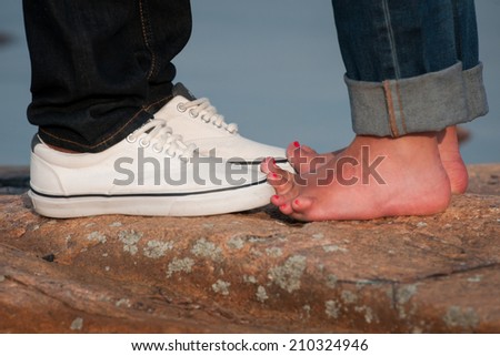 Young lovers in denim touch toes