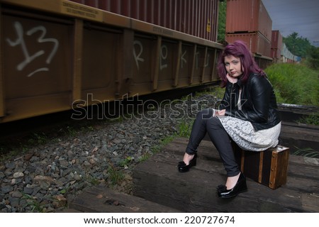 Sad runaway teen girl waits for train to escape her problem