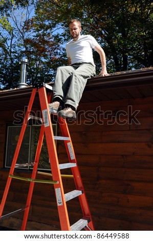 Man on getting on to ladder from roof