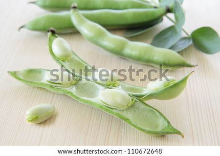 Pod with white beans on white board