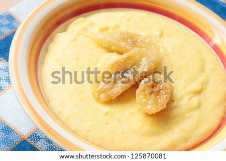 Milk porridge of maize grain with fried bananas in bowl
