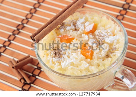 Rice pudding with pumpkin, sugar and cinnamon in glass cup