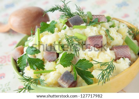 Mashed potatoes with pieces of herring, dill, parsley and chives
