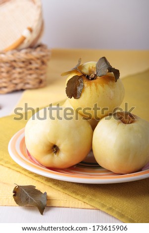 Four pickled apples on a striped plate
