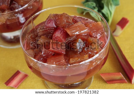 Two glasses with rhubarb jam on a yellow napkin
