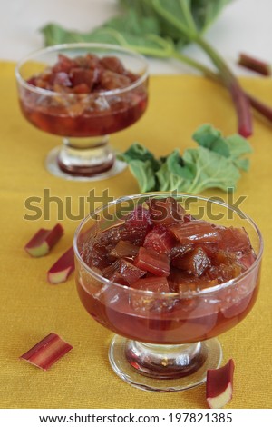 Two glasses with rhubarb jam on a yellow napkin