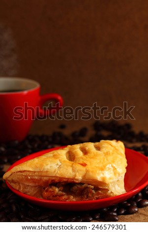 Black coffee in red cup ,  coffee bean and mushroom puff pastry.