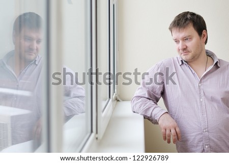 Courageous middle age man looking at snow into the window