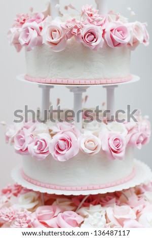 Delicious white wedding cake decorated with pink cream roses