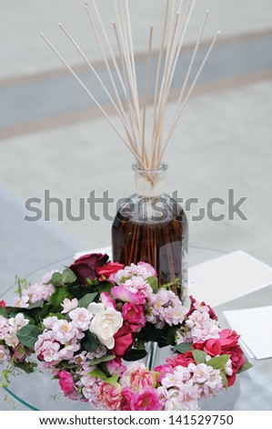 Aroma diffuser with bamboo sticks mounted and wreath of flowers, focus on wreath