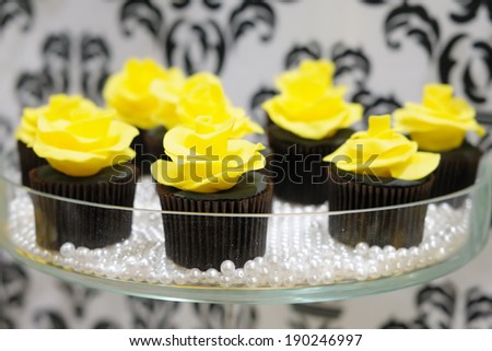 Black and yellow cupcakes on glass plate