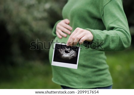 Woman holding ultrasound scan of pregnancy