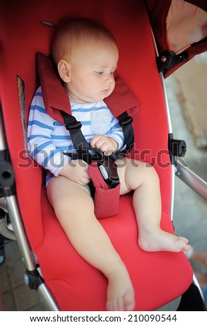 Portrait of little baby boy in a stroller