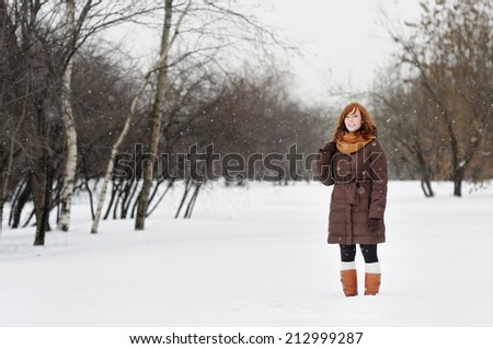 Young beautiful woman walking in winter park